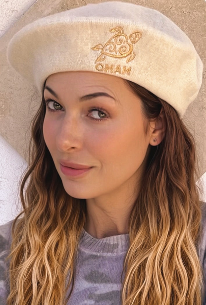 Woman wearing a beige beret with 'OMAM' MUSEUM LOGO 
Gold embroidery 🪡 