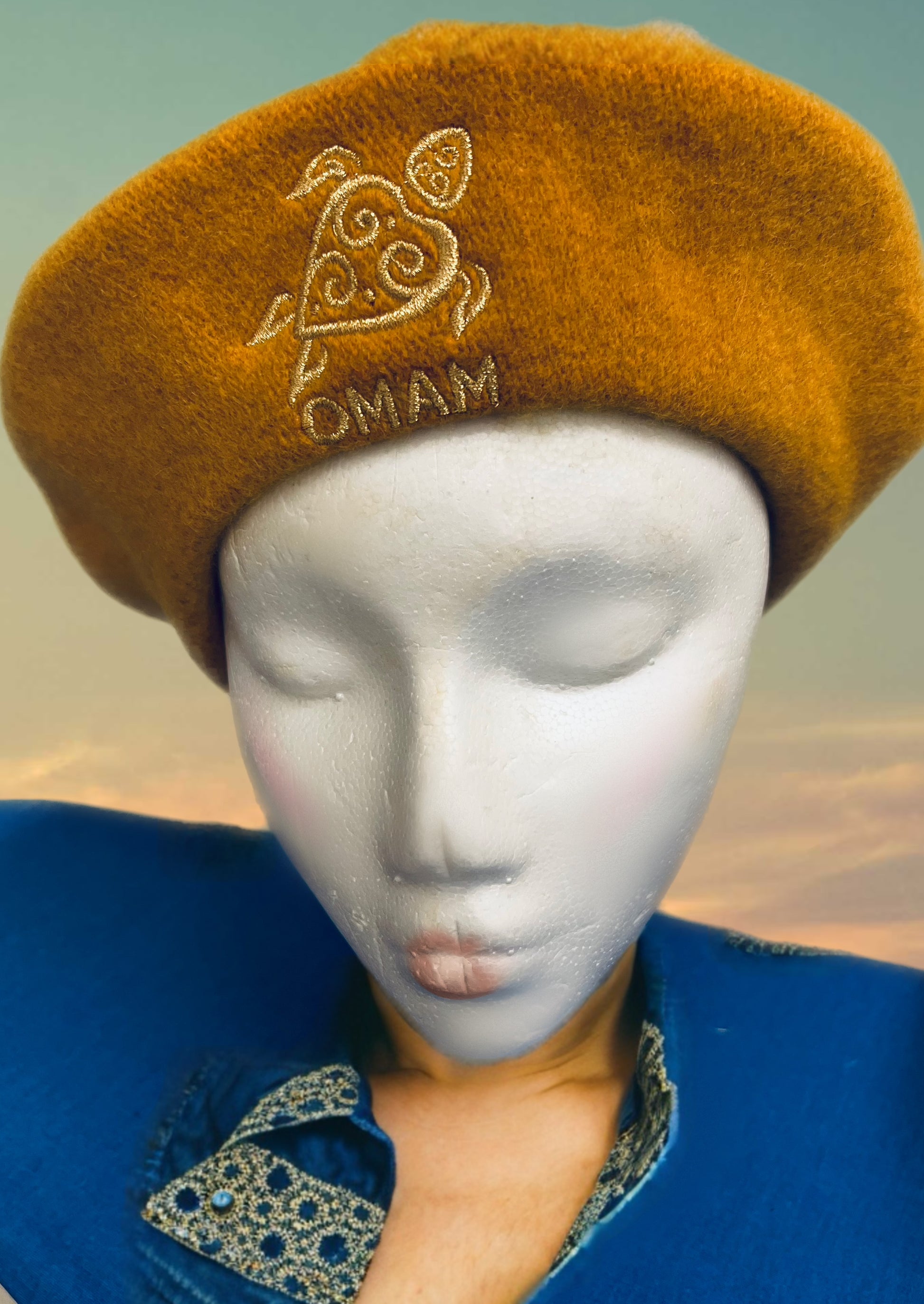 Mustard yellow Beret with OMAM turtle logo in gold embroidered thread on mannequin